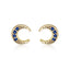 Gold crescent moon earrings with blue gemstones on a white background
