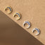 Pair of gold and silver Moon earrings with blue gemstones on a brown background