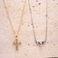 Two necklaces, one gold Crucifix and one silver angle wings on a textured beige surface.