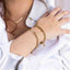 Custom Name Bracelets Gold – Waterproof & Tarnish Free. Gold bracelets on a person's wrist with a white background
