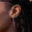 Close-up of an ear wearing a set of earrings with gemstones.