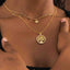 Gold necklace with star, moon, and sun pendants on a textured beige background-Gold Celestial Gypsy Necklace ā Station Necklace
18K Gold-Plated | Celestial | Hypoallergenic styled with Gold necklace with a tree of life pendant on a person's neck