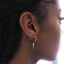 Everyday Pieces with Meaning: Sterling silver hoop earrings with a pointed design on a model.