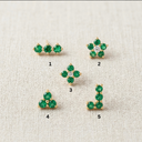 Set of green gemstone earrings on a textured beige background