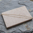 14K Gold Double Layer Beaded Anklet, Hypoallergenic & Trendy - A delicate gold chain necklace draped across a rectangular beige stone slab, set against a textured gray slate background.