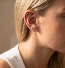 Zodiac Constellation CZ Flat Back Earring – 16G Push Pin Cartilage Stud-Close-up of a woman's ear wearing multiple silver ear piercings: a small hoop in the lobe, a curved barbell, and a star cluster cartilage piercing.