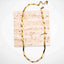 Sculpted Link Necklace in PVD gold-plated stainless steel  on a textured beige square background
