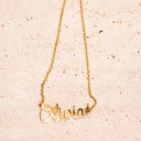 Personalised Name Necklace – 18K Gold-Plated

Waterproof | Hypoallergenic | Made-to-Order, Gold 'Olivia' necklace on a textured beige background