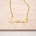 Gold necklace with 'Antonette' pendant on a beige background. Personalised Name Necklace – 18K Gold-Plated

Waterproof | Hypoallergenic | Made-to-Order