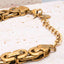 Lobster clasp and extender chain detail on gold link bracelet.