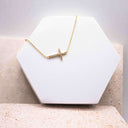 Cross Link Bracelet displayed on a white hexagonal stand, featuring gold-plated cross design.