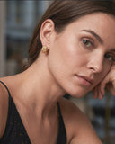 Close-up of a woman wearing Chunky Watch Link Huggie Hoop Earrings 
