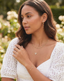Woman wearing a white dress with jewelry in a garden setting
