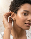 Woman wearing Dainty CZ Drop Chain Stud Earrings with a neutral background