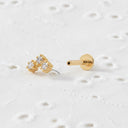 Gold push pin earring with floral design on a white background