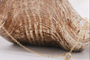 Mini CZ Gold necklace with a small pendant on a textured surface
