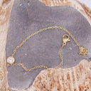 Mini CZ Necklace – Gold PVD Plated Stainless Steel. Gold bracelet with a clasp on a stone surface