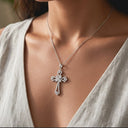 Close up of Radiant cross necklace silver on a woman wearing a light-coloured top