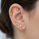 Close-up of an ear with multiple diamond stud earrings.