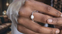 Close-up of a hand wearing Pearl Beaded Stretch Ring – Easy On & Off | Gold or Silver Tone on a blurred background