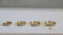 Four Earrings gold rings with diamond accents on a light background