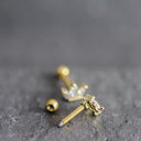 Gold earrings on a textured gray surface