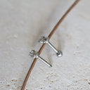 Silver stud earrings on a light brown surface