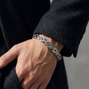 Silver bracelet on a person's wrist with a blurred background