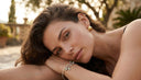 Woman lying down with Ella & Faith London jewellery on, outdoors
