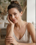 Woman wearing a delicate necklace in an indoor setting