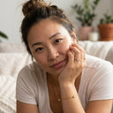 Woman sitting on a couch with plants in the background