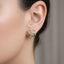 Close up of Gold Knot Moissanite earring worn by a person with a neutral background