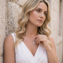 Woman wearing a necklace with a stone wall background