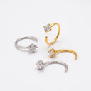 Set of gold and silver nose rings with clear gemstones on a white background