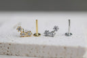 Gold and silver earring studs on a textured surface