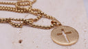 Engraved cross necklace featuring the Lord's Prayer on a circular stainless steel pendant with cut-out cross design.