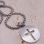 The back of a Silver stainless steel Lord’s Prayer Cross Necklace with engraved prayer and circular pendant design