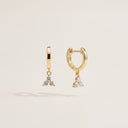 Mini Moissanite Drop Hoop Earrings- Three Stone Charm- Gold hoop earrings with diamond-like stones on a light beige background