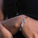 Close-up of a person's wrist with s925 Sterling Silver Bell Bangle – Handmade & Adjustable 100% 925 Silver | Adjustable Fit | Hypoallergenic
 on a wrist with a blurred background