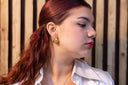 Sculpted Pearl-Embellished Hoops Woman with red hair wearing a white shirt against a wooden background whilst wearing Sculpted Pearl-Embellished Hoops 