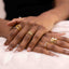 Close-up of hands wearing multiple gold rings on a white surface including Adjustable Freshwater Pearl Ring – 18K Gold Plated Statement Jewellery

Gold-Plated | Molten Design | Hypoallergenic
