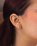 Mini CZ Stud Earrings – 4mm Gold PVD Stainless Steel with round cut cubic zirconia on a model's ear.