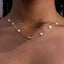 Clover and Pearl Station Necklace – Gold or Silver. Gold necklace with pearls on a person's neck