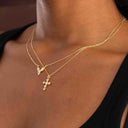 Gold Cross Necklace  on a person wearing a black top.