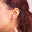 Moon & Star Drop Earrings – Gold or Silver. Fine Jewellery | 925 Sterling Silver | Midnight Blue CZ StonesClose-up of an ear wearing a gold earring with a small gemstone.