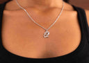 Silver necklace with a pendant on a person wearing a black top.
