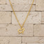 Gold necklace with a heart-shaped pendant on a white background