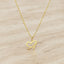Gold Necklace on a beige stone background 