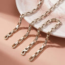 Elara Link Bracelet - silver chain on a pink  stone surface