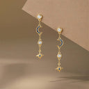 Moon & Star Drop Earrings display on a board
